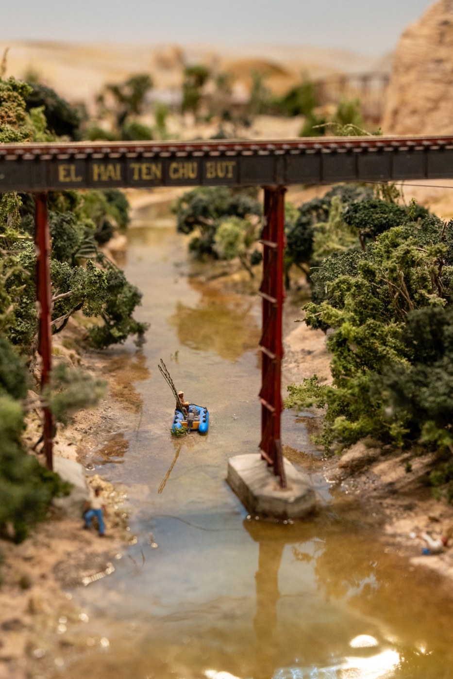 Miniature landscape with a river, bridge and layered vegetation