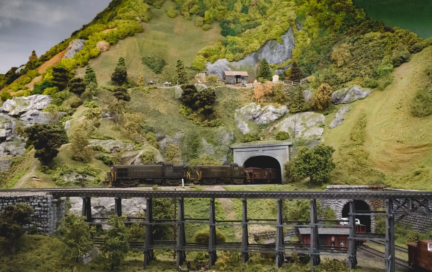 Model railway landscape blending tracks, vegetation and hills