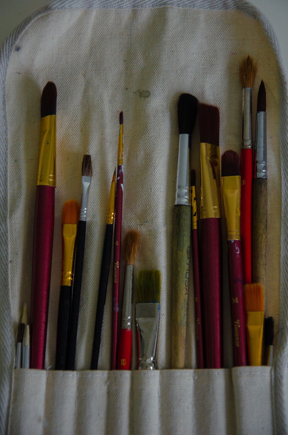 Different brush shapes held in a fabric roll