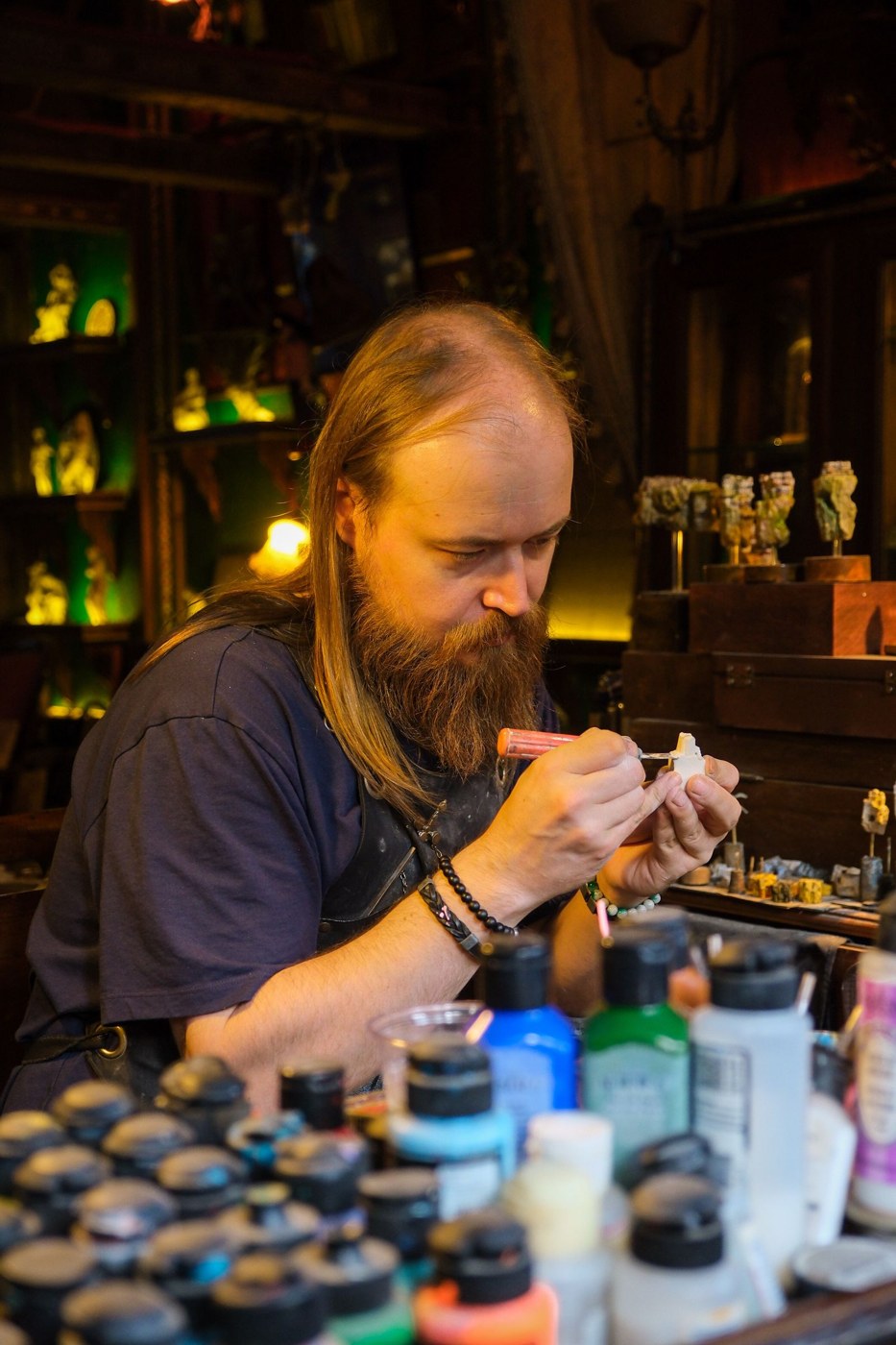 Model maker painting a miniature at a workbench